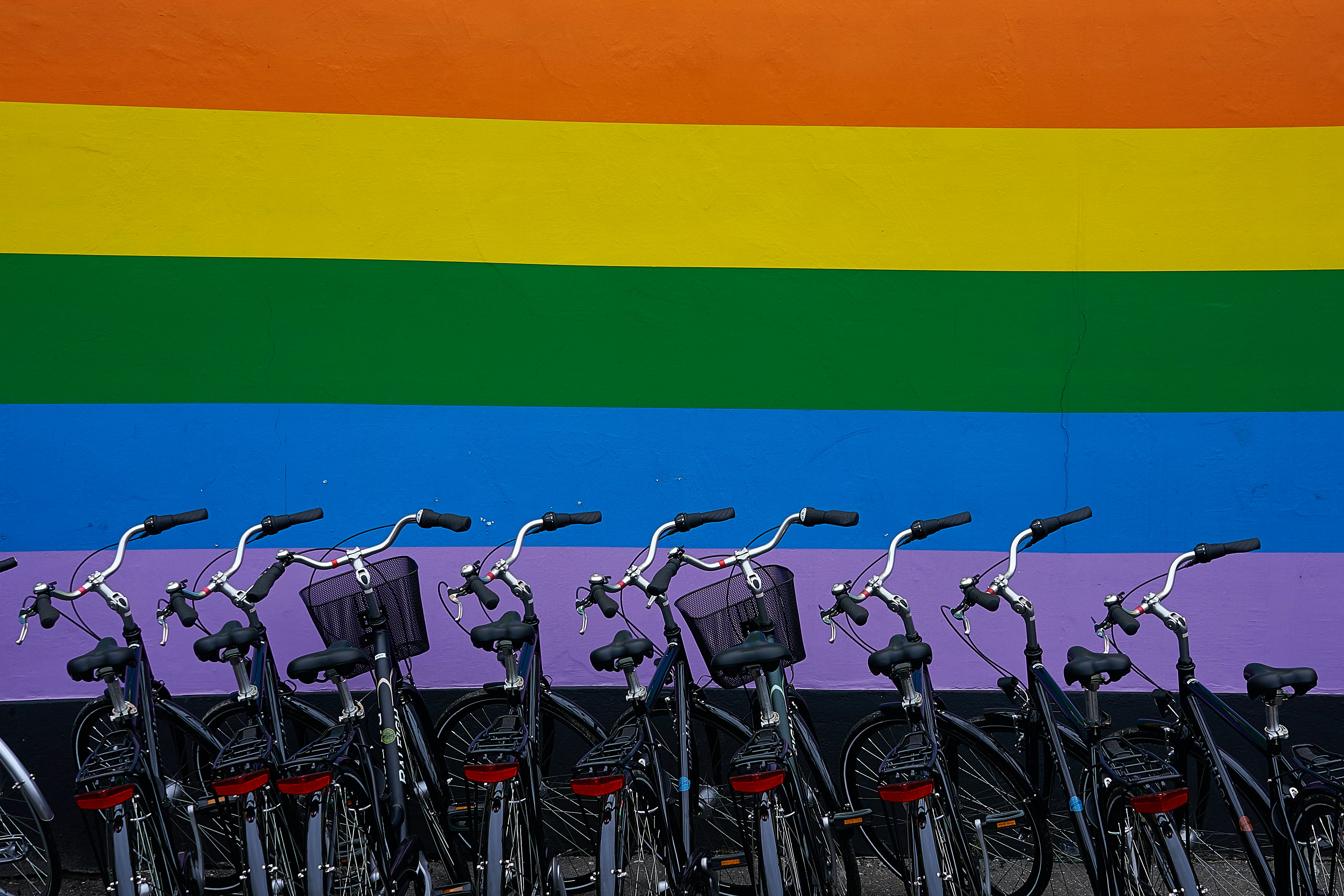 black commuter bikes parked near multicolored wall